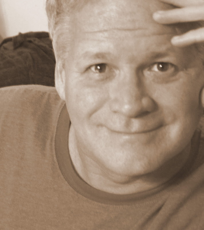 Mark Williams in sepia, close-up, hand in his hair